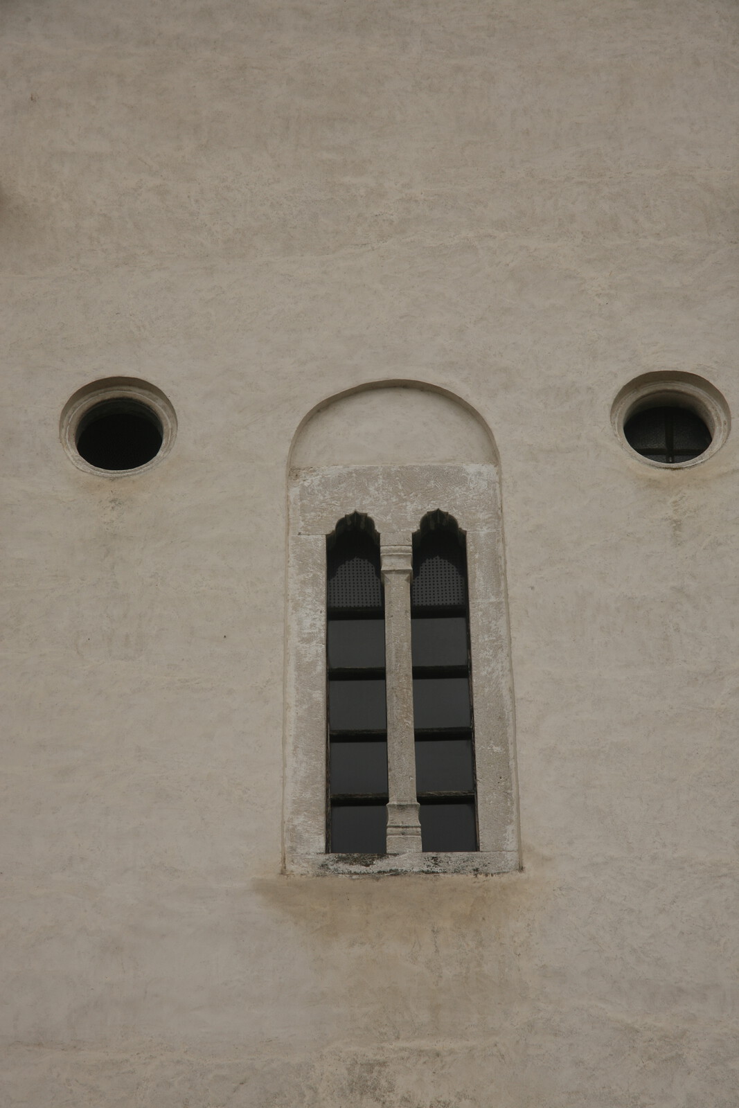 Mullioned window (bifora) and two oculi on the western facade of church
