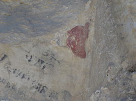 Остаци плаве позадине и црвене бордуре на каменој греди изнад портала