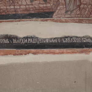Partially preserved inscription below the composition
