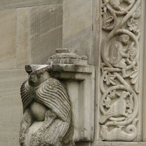 Kneeling figure on the south side of the window