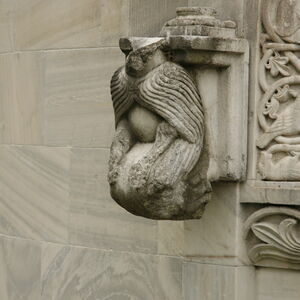 Kneeling figure on the south side of the window